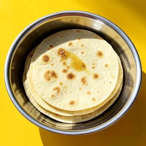 A stack of soft whole-wheat flatbreads brushed with ghee