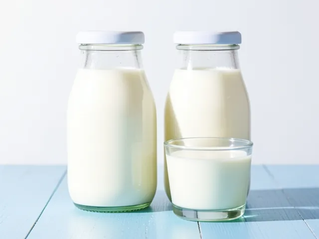 Two glass bottles of fresh milk with a small glass in front