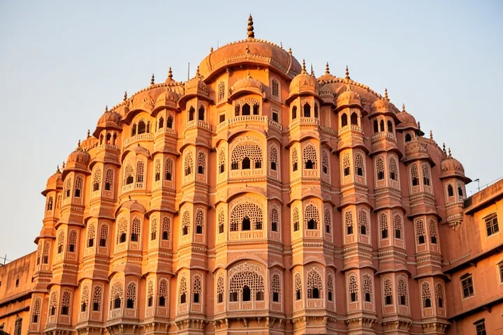 The pink sandstone face of Hawa Mahal in Jaipur, lit by late sun