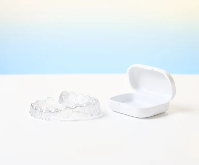 Clear aligner trays beside their case
